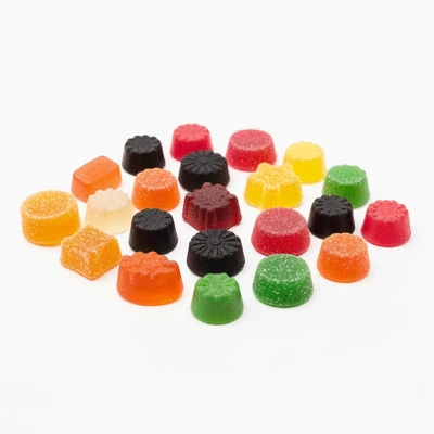 Assortment of colorful CBD gummies in different shapes and flavors on a clean white background