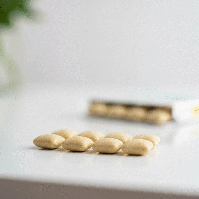 Close-up of a pack of CBD gum on a clean surface, showing individual pieces of gum, with a blurred background