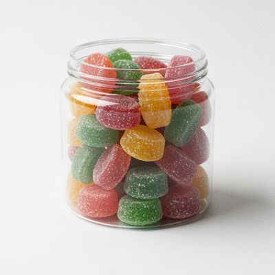 Assortment of colorful CBD gummies in a clear jar on a clean white background, focus on texture and vibrant colors
